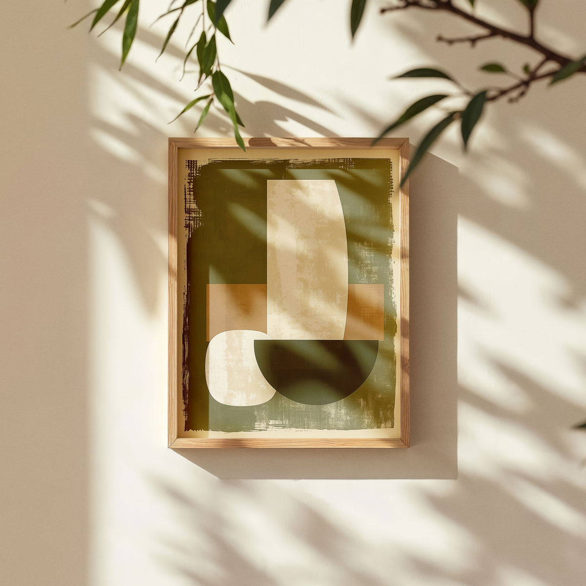 Abstract botanical wall art print featuring earthy olive green and beige shapes, framed in natural wood, with soft sunlight and leafy shadows enhancing the calming mood.