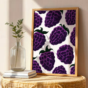 Blackberry wall art print featuring vibrant purple blackberries and green leaves on a warm background.
