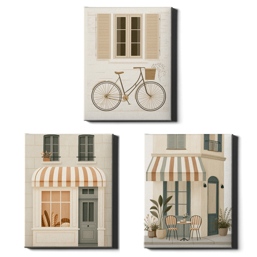 Three framed wall art prints showing stylized Parisian street scenes: a bicycle under shutters at the top, a storefront with a striped awning at lower left, and a cafe exterior with table and chairs at lower right, displayed on a white background.